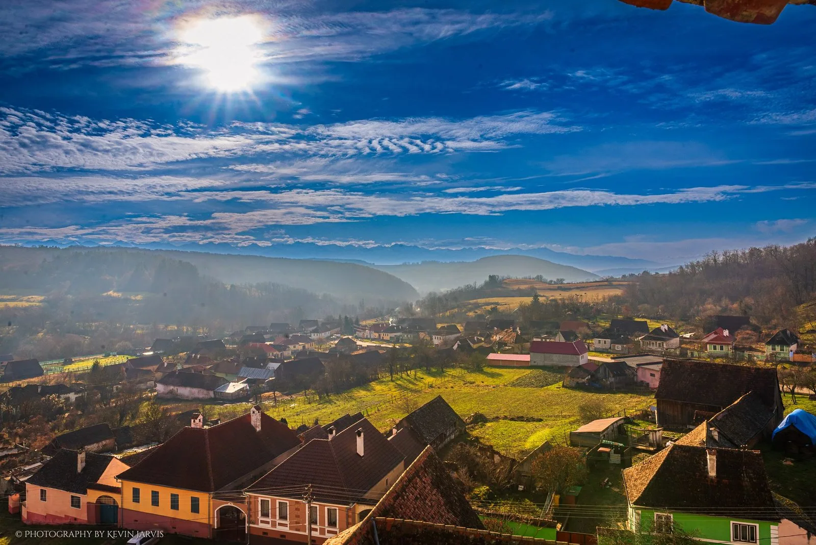 Low winter sun over the village roofs, the Făgăraș ridge white on the horizon.