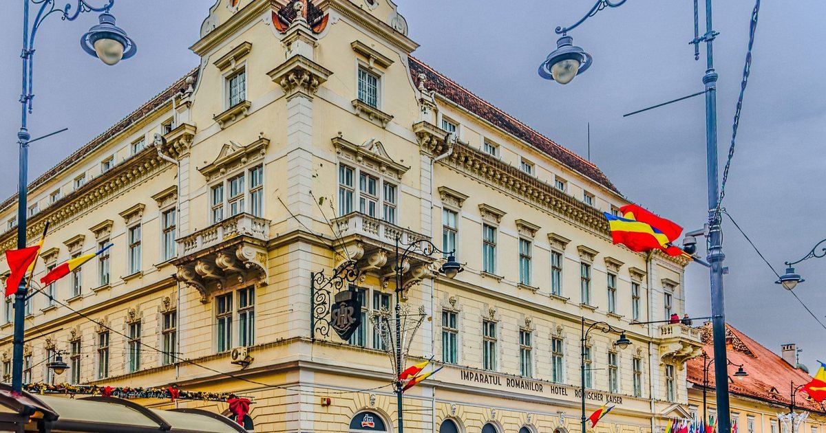 The Împăratul Romanilor hotel on the square in Sibiu, flags out.